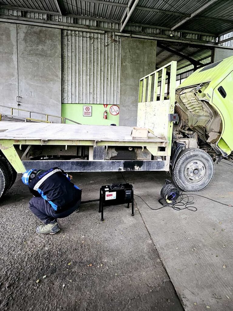 Proses pengambilan sampel uji emisi kendaraan logistik oleh teknisi AdhikariLab