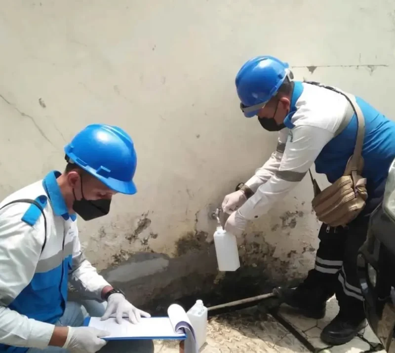 teknisi adhikarilab mengambil sampel air bersih untuk pengujian kualitas air rumahan sumber sumur pdam