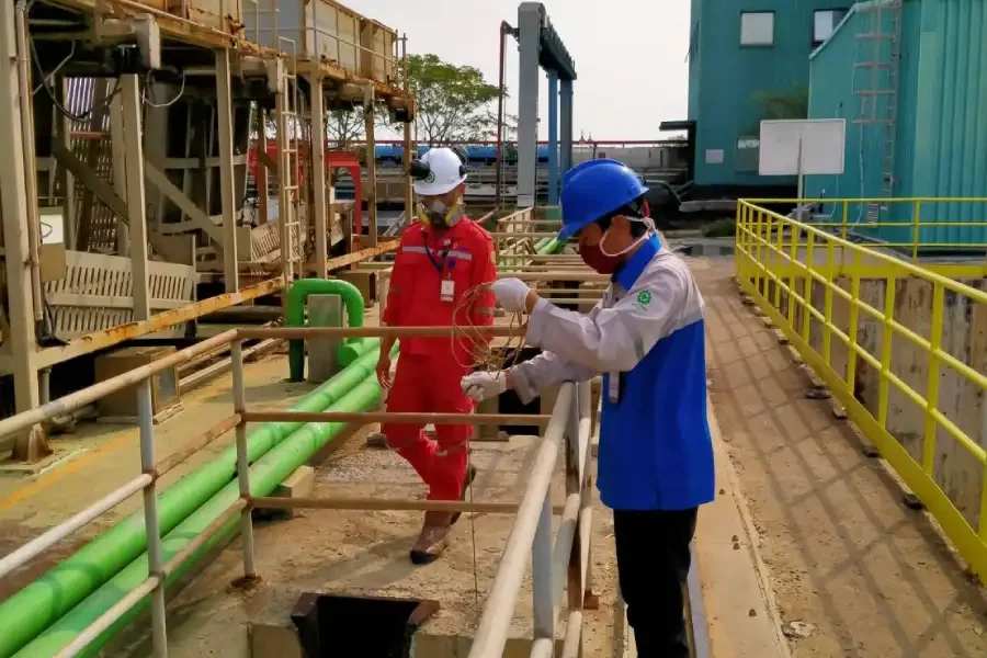 teknisi adhikarilab mengambil sampel air limbah dari IPAL industri