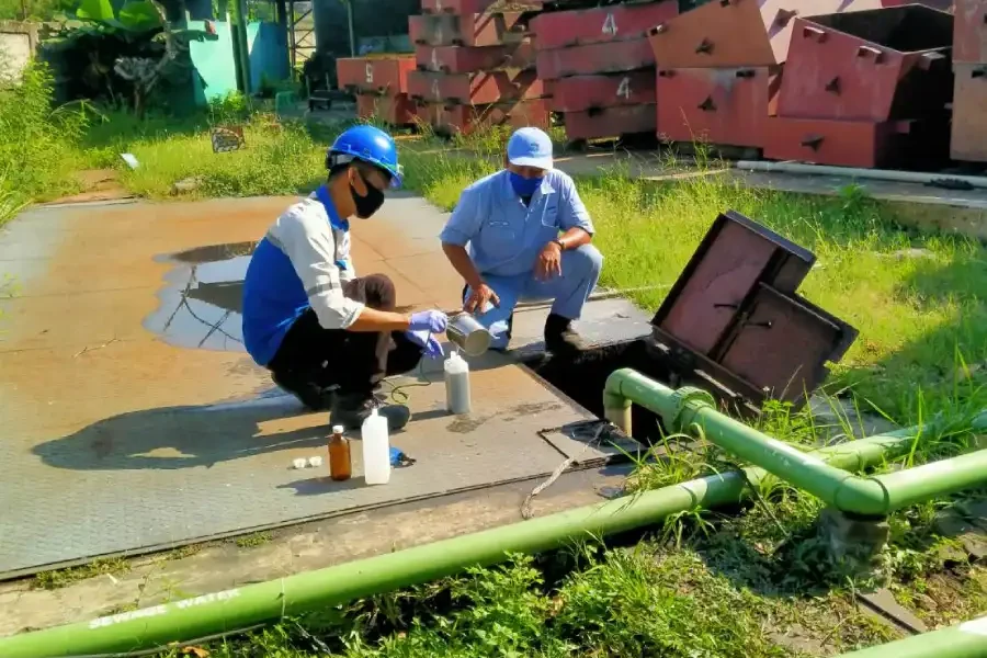 teknisi adhikarilab mengambil sampel air limbah dari IPAL industri